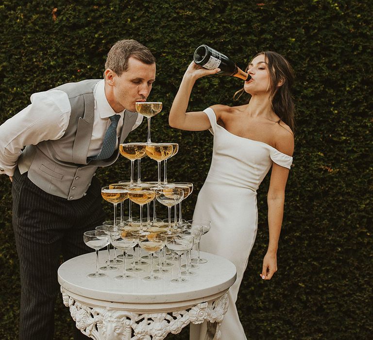 Bride and groom having fun with their champagne tower