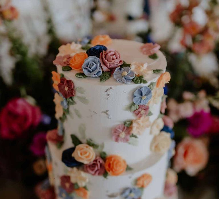 Three tiered iced wedding cake with spring flower icing decorations