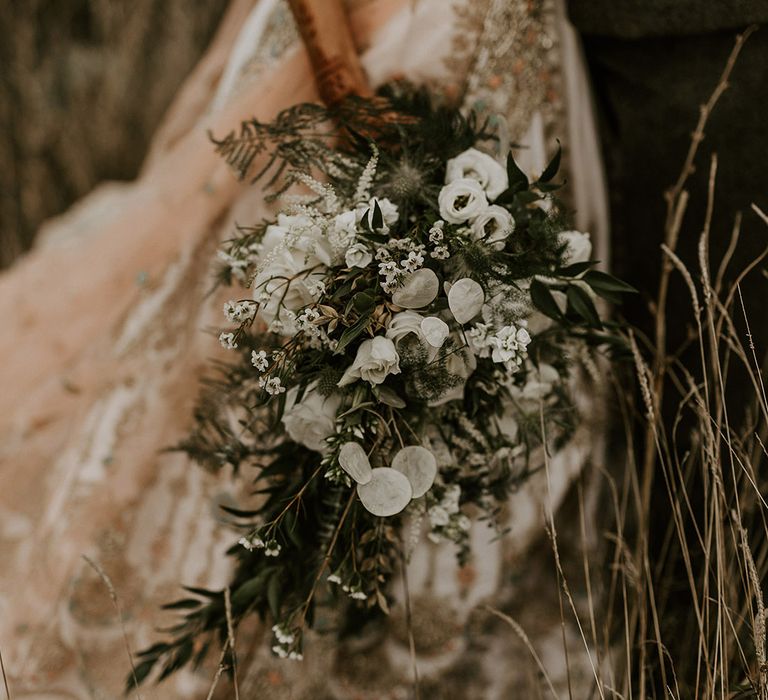 Bride holding classic and traditonal all white wedding bouquet 