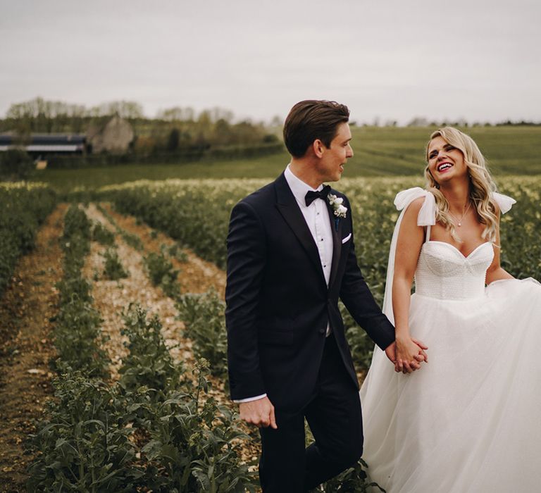 The bride and groom pose together as they walk around their wedding venue together 