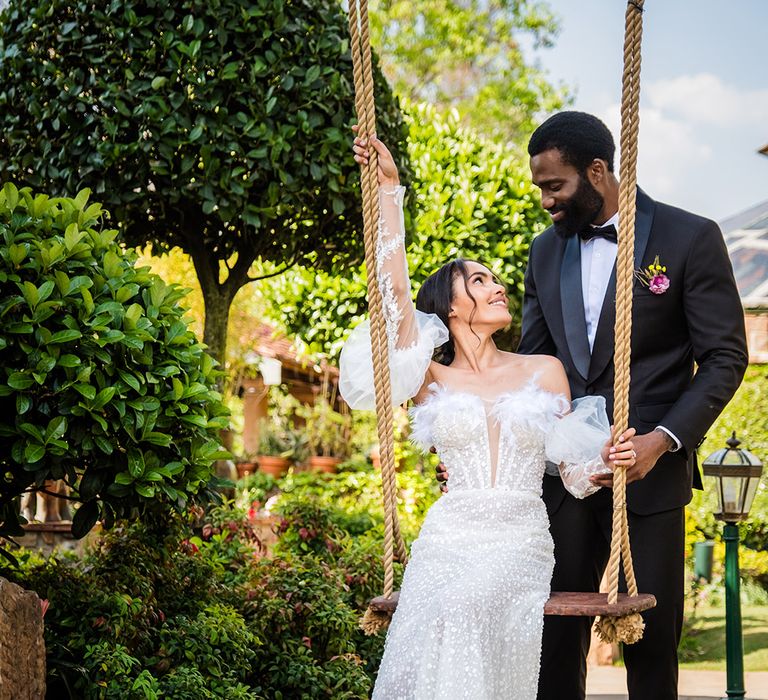 Groom wearing black tuxedo with the bride in an off the shoulder custom Milla Nova wedding dress 