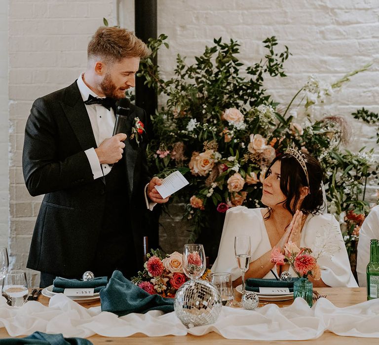 Groom stands with microphone to read out his wedding speech 