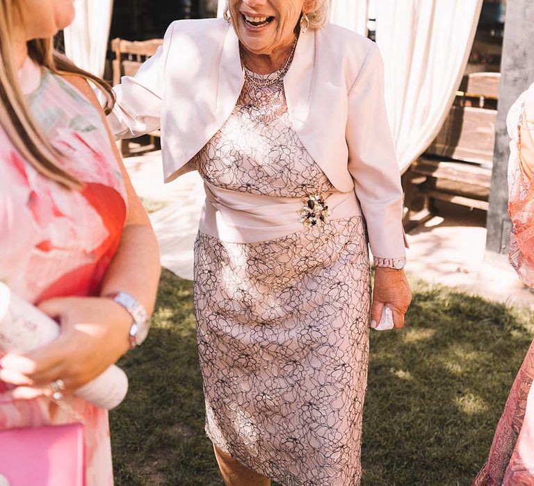 Wedding guest fashion with guest wearing pale pink outfit with matching pink hair bow 