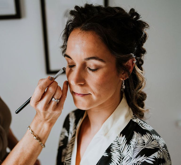 Bride gets her makeup done as she gets ready for the wedding ceremony 