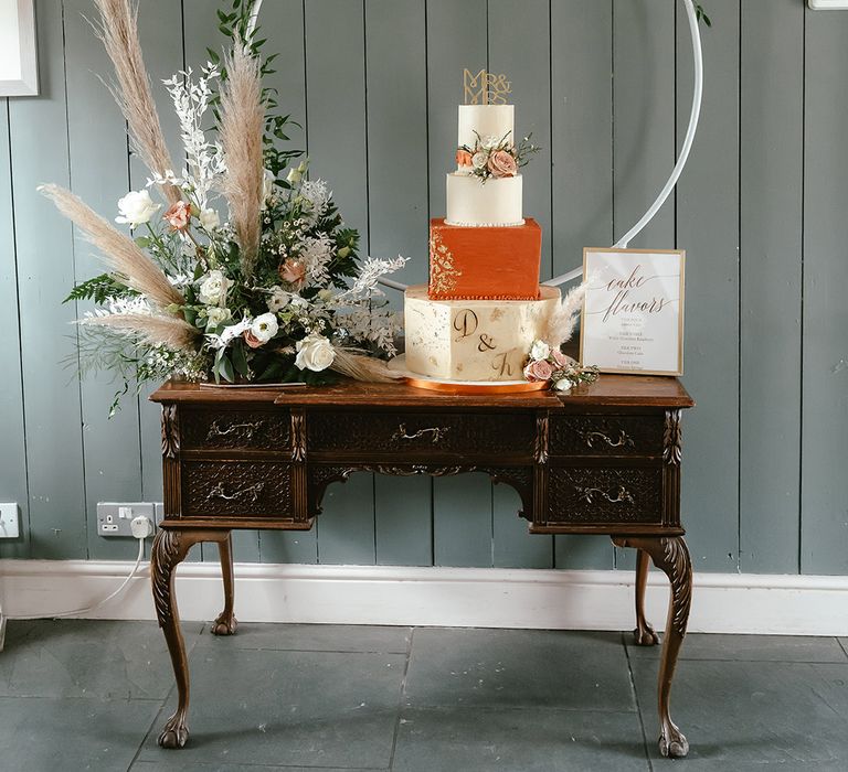 White and orange wedding cake with personalised cake topper and cake moongate 