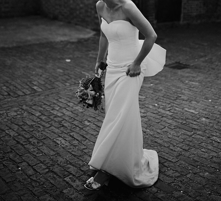 Bride in elegant strapless wedding dress with bow detail 