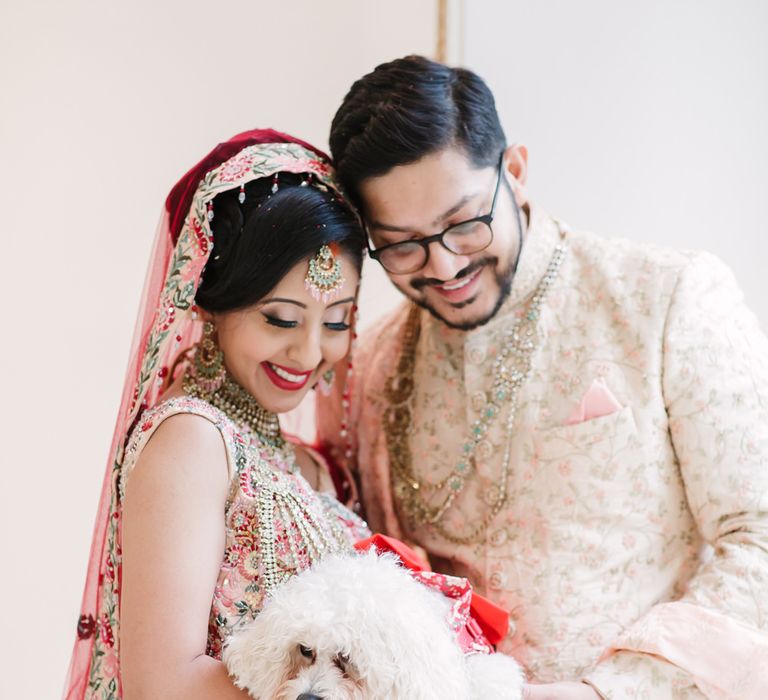 Portrait of the bride and groom with their pet Bichon Frise dog