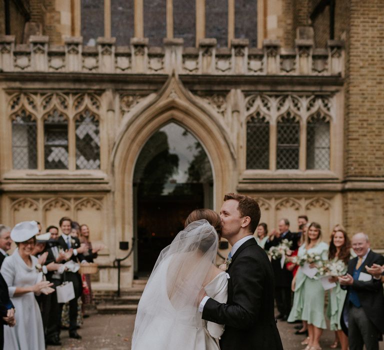 Church wedding groom kissing his new bride with veil 