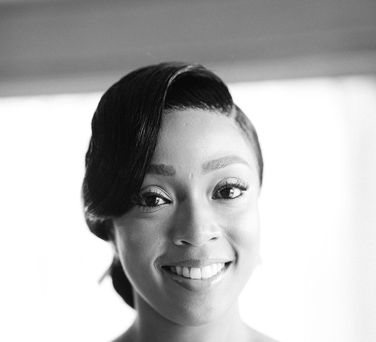 Black bride with low bun wedding hairstyle and sweeping fringe