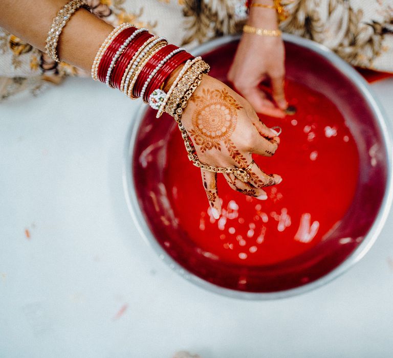 Brides hands wearing golden jewellery and painted with Henna