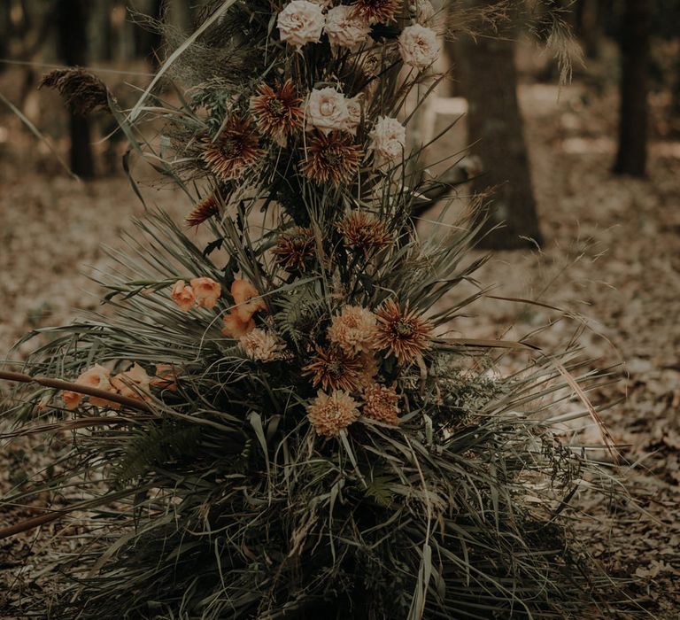 Dried grass and fresh flowers for floral arch with orange dahlias 