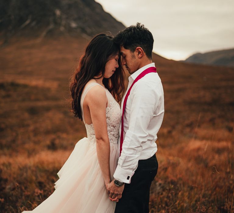 Couple stand together holding hands 