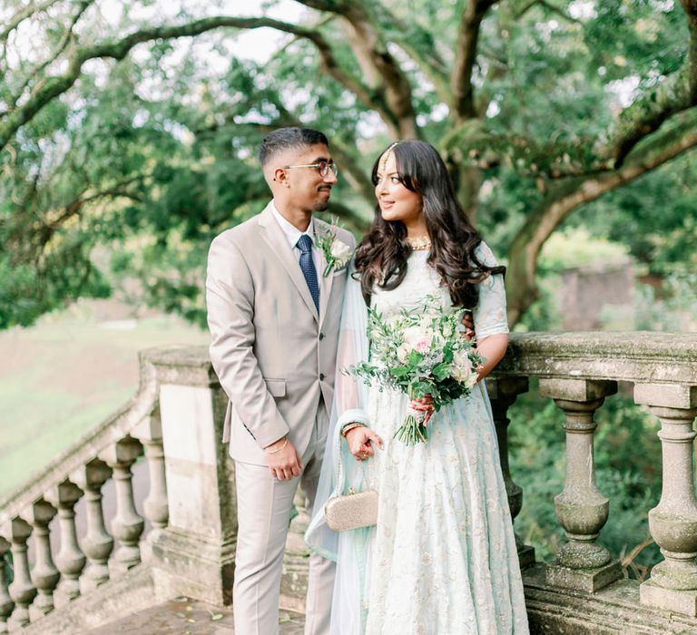 Interfaith wedding with Muslim bride in a mint sari and Sikh groom in a beige suit 