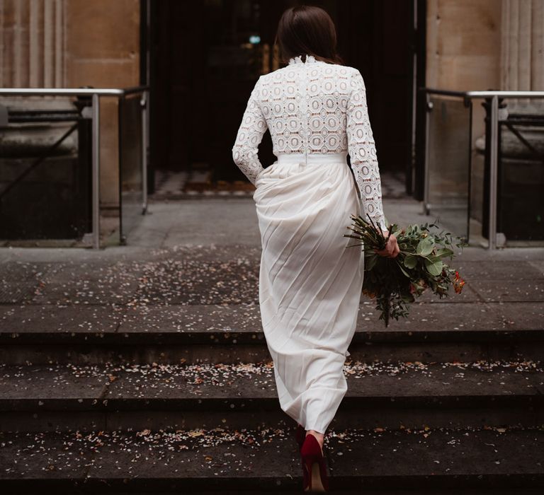 Bride in Self Portrait dress holding colourful bouquet walks up steps to Bristol Registry Offie 