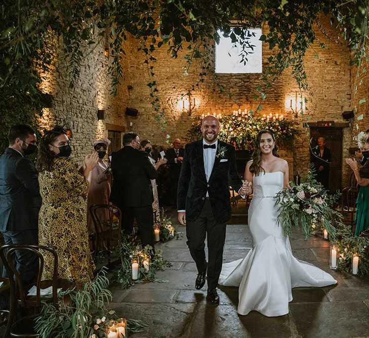 Bride and groom descending up the aisle as husband and wife at intimate Cripps Barn ceremony decorated with natural wedding flowers 