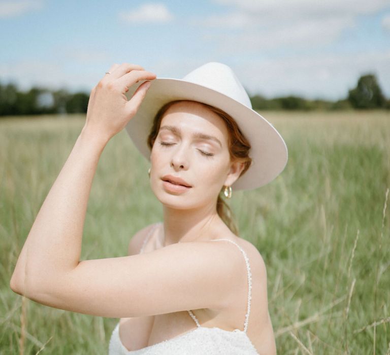 Bride in the fields at Berwick Lodge wearing a bridal stetson hat