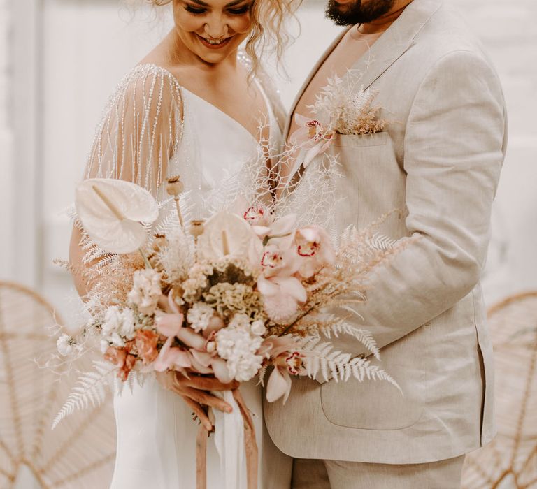 Bride and groom with pink and white florals for a tropical wedding theme