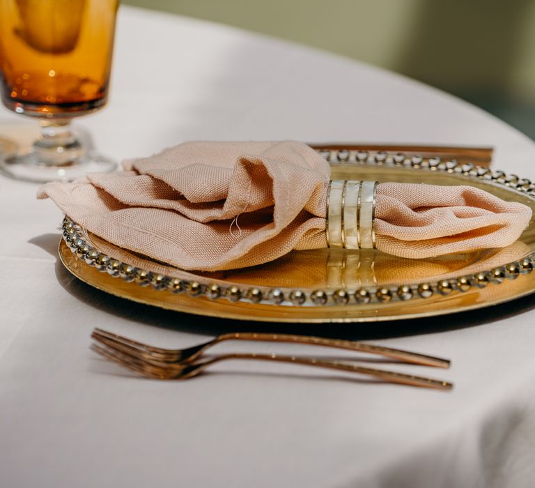 Golden plates with pastel pink rustic napkins