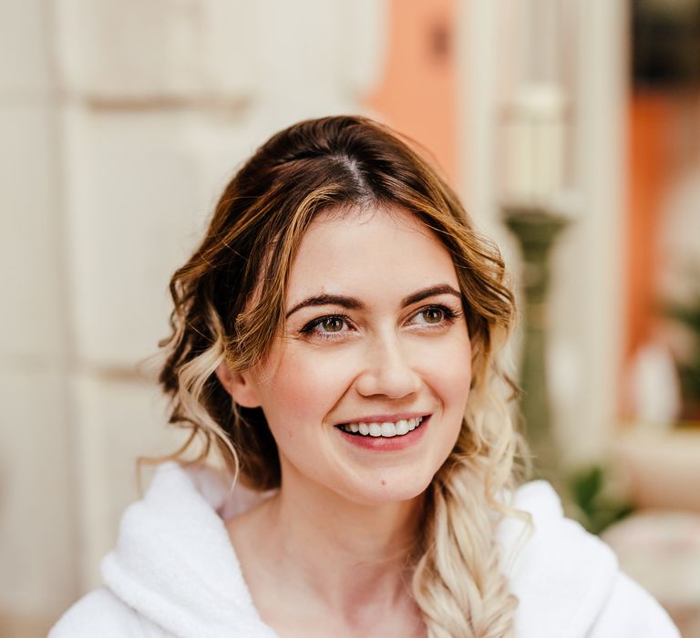 Blonde bride has her makeup done on the morning of her wedding