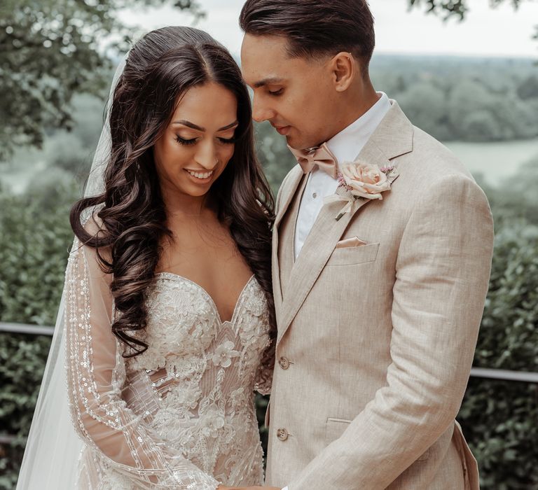 Bride & groom stand together outdoors after first look moment as bride wears Milla Nova wedding gown