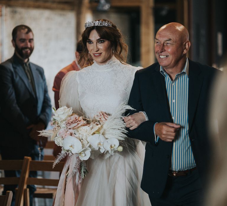 Bride walks down the aisle with her father on her wedding day