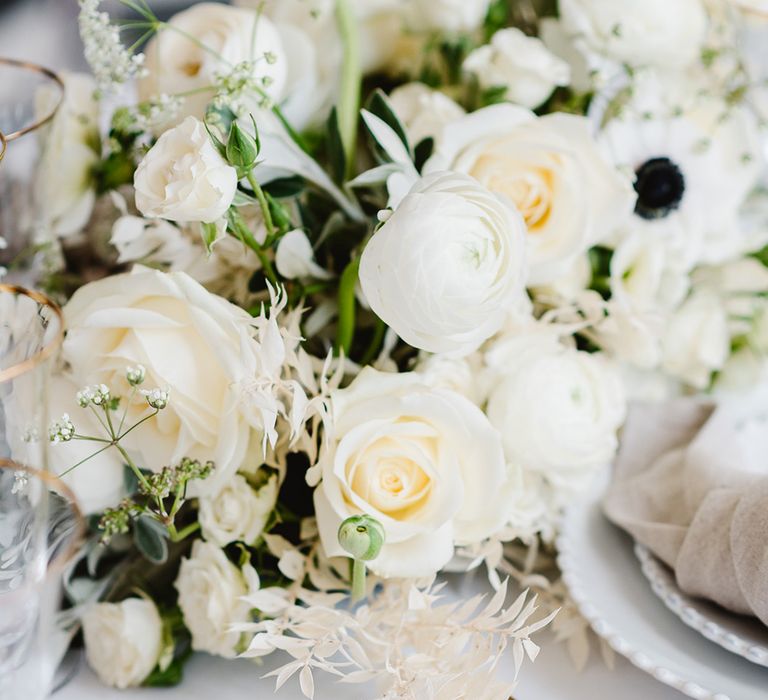 Close up of a black and white wedding bouquet including ranunculus, roses and anemones.