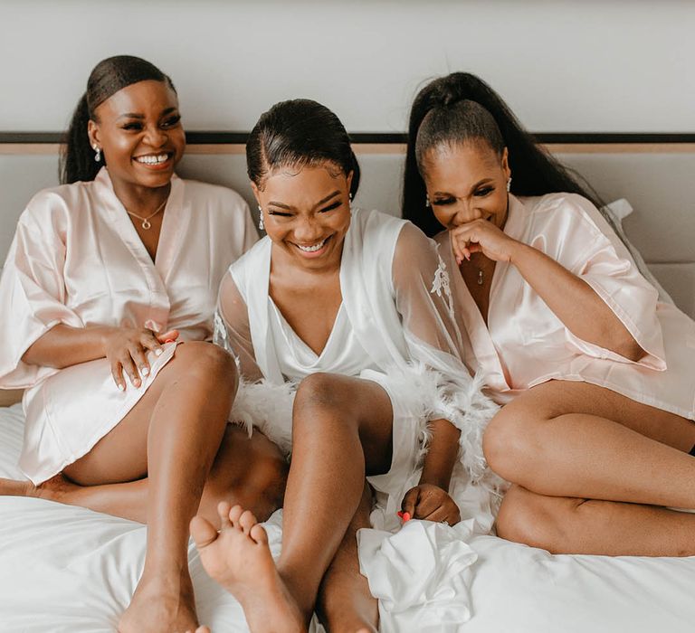 Bride laughs with her bridesmaids on the morning of her wedding