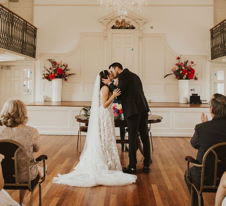 Bride & groom kiss on their wedding day during wedding ceremony