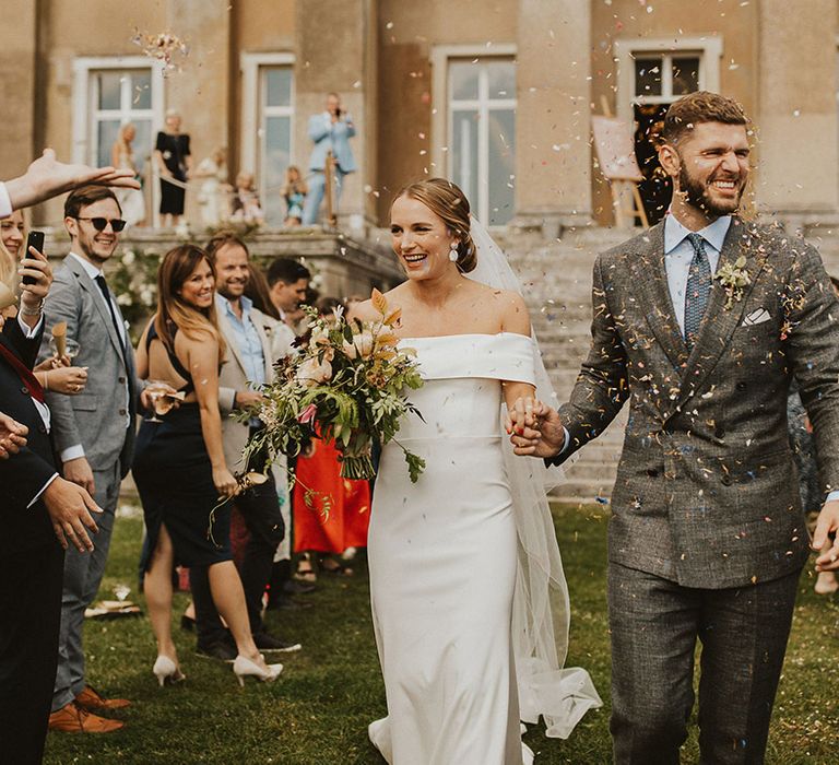 Bride & groom walk through confetti on their wedding day