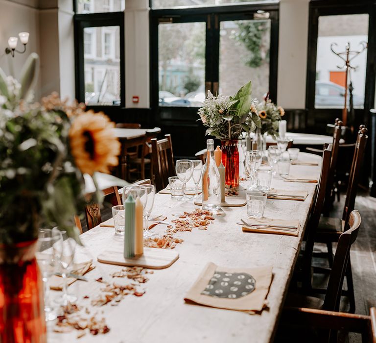 Intimate pub wedding reception with coloured glass bottle centrepieces 