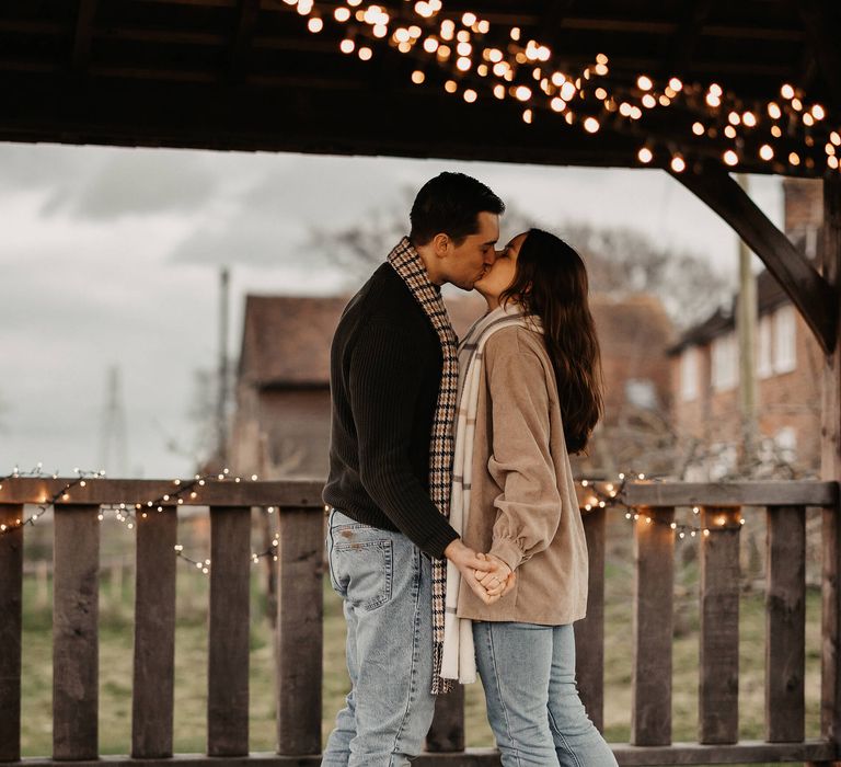 Engagement portraits with bride and groom-to-be kissing at The Cherry Barn 