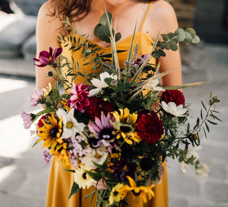 Bride holds colourful floral bouquet