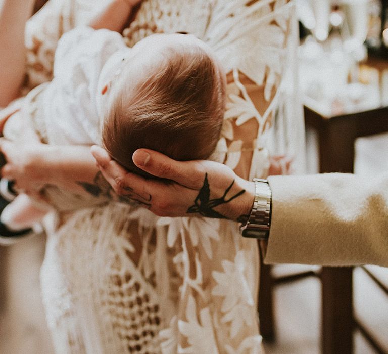 Bride holds baby on the day of her wedding