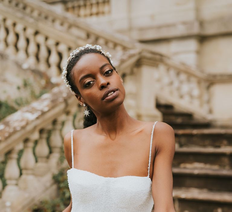 Black bride in a Made With love sparkly wedding dress with thin straps wearing a jewelled headband and matching earrings 