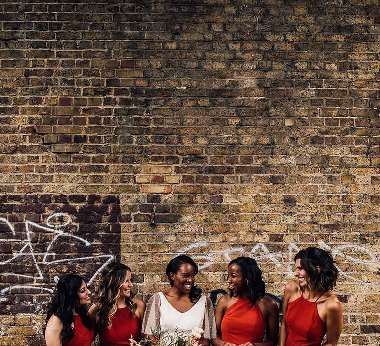 Bridal party in burnt orange bridesmaids dresses and bride in bespoke bridal separates at urban wedding 