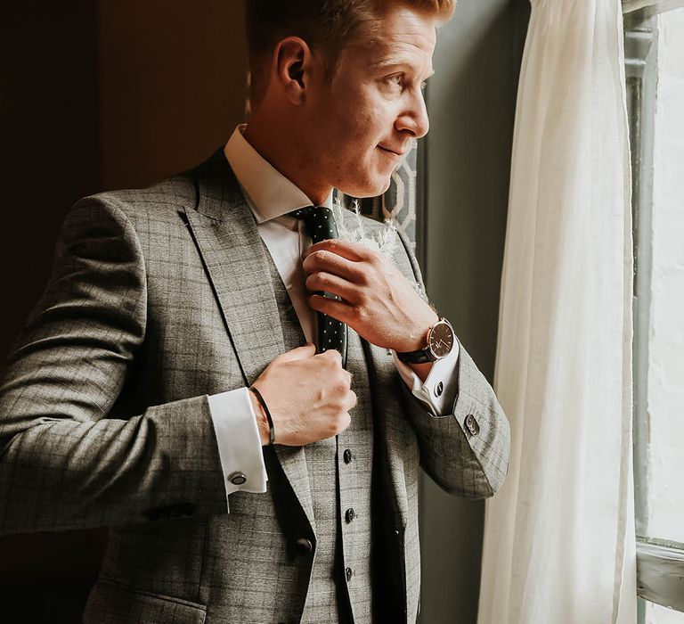 Groom in check three piece suit for wedding