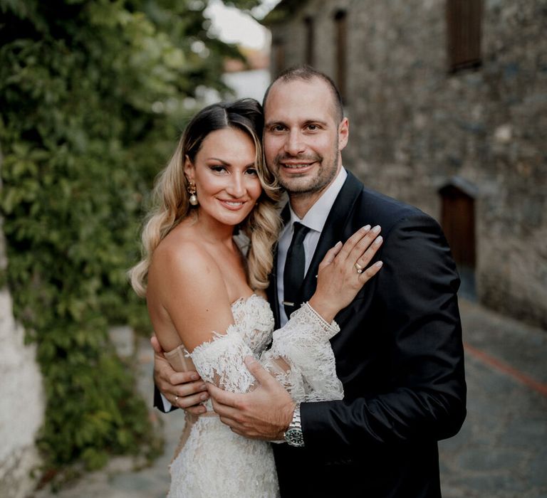 Bride leans in and places her hand on groom on her wedding day