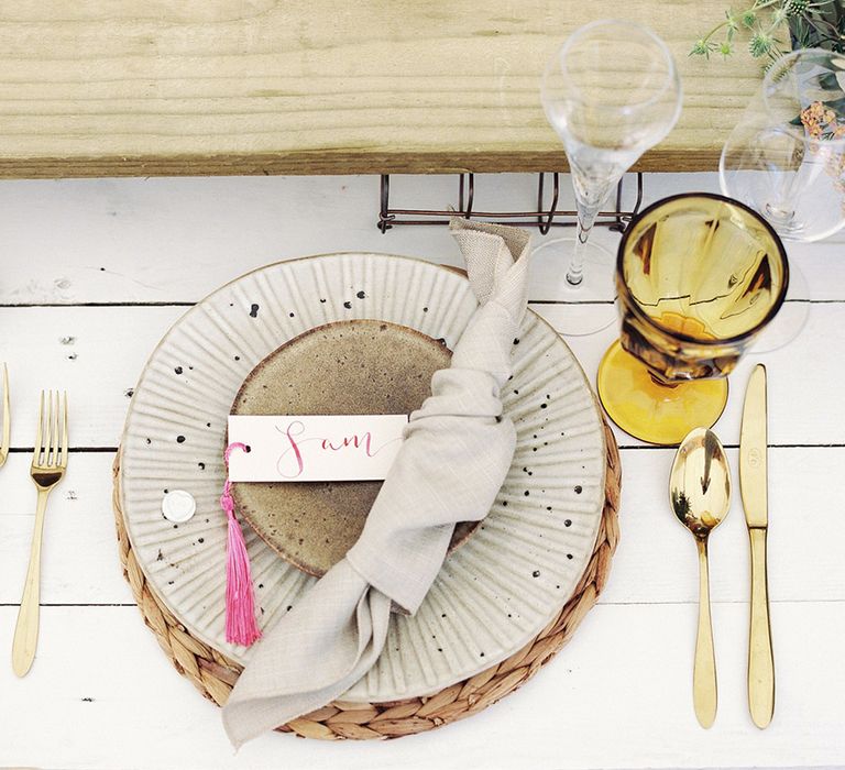 Neutral wedding place setting with gold cutlery 