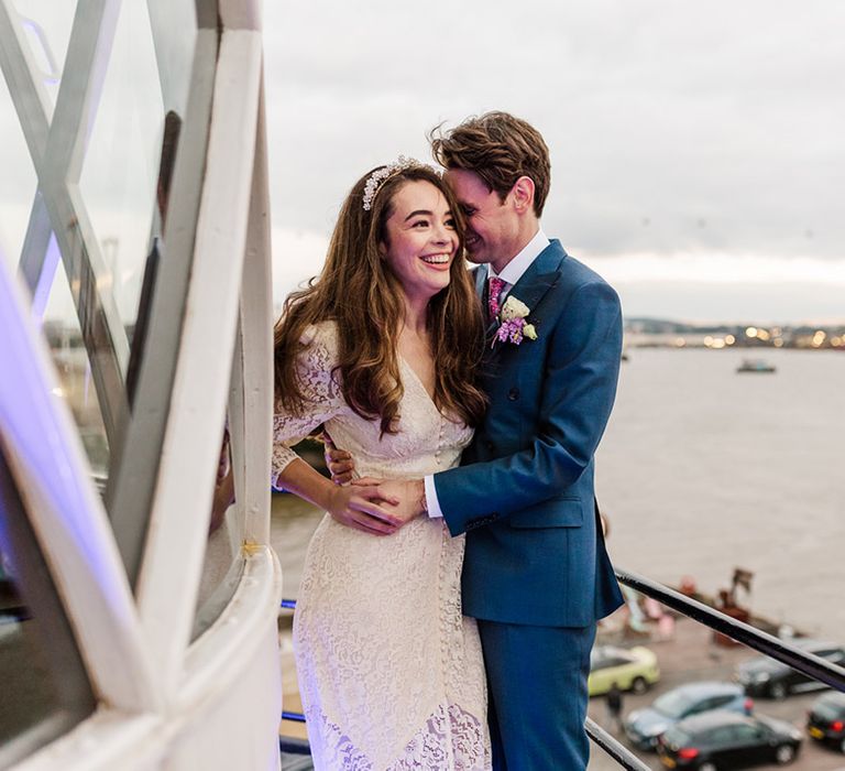 Bride and groom hug and enjoy their view of London city at industrial wedding venue, Trinity Buoy Wharf 