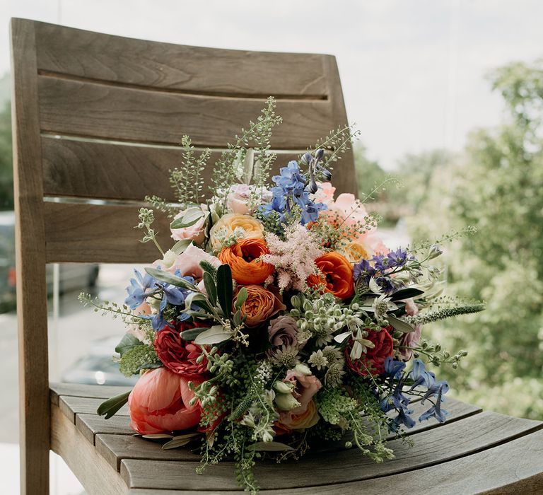 Blue, orange, and pink flowers for wedding bridal bouquet at summer wildflower wedding 