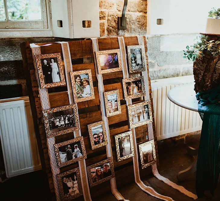 DIY pallet photo wall beside tree trunk cake stand for beach wedding in Cornwall 