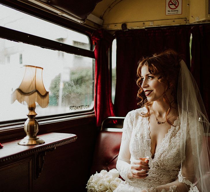 Bride wears deep red lipstick and her red hair tied into curled half-up half-down hair styling 