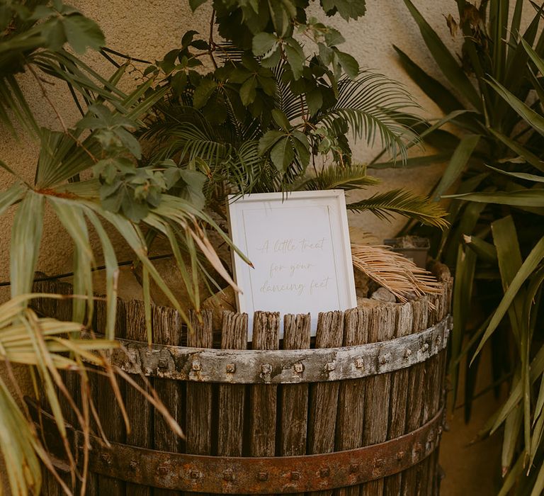 Baskets filled with white sandals and sparklers for wedding reception party