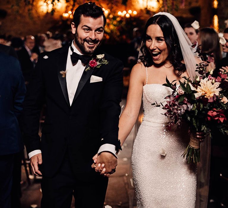 A happy and exciting moment for the bride and groom as they exit their ceremony as a married couple to confetti