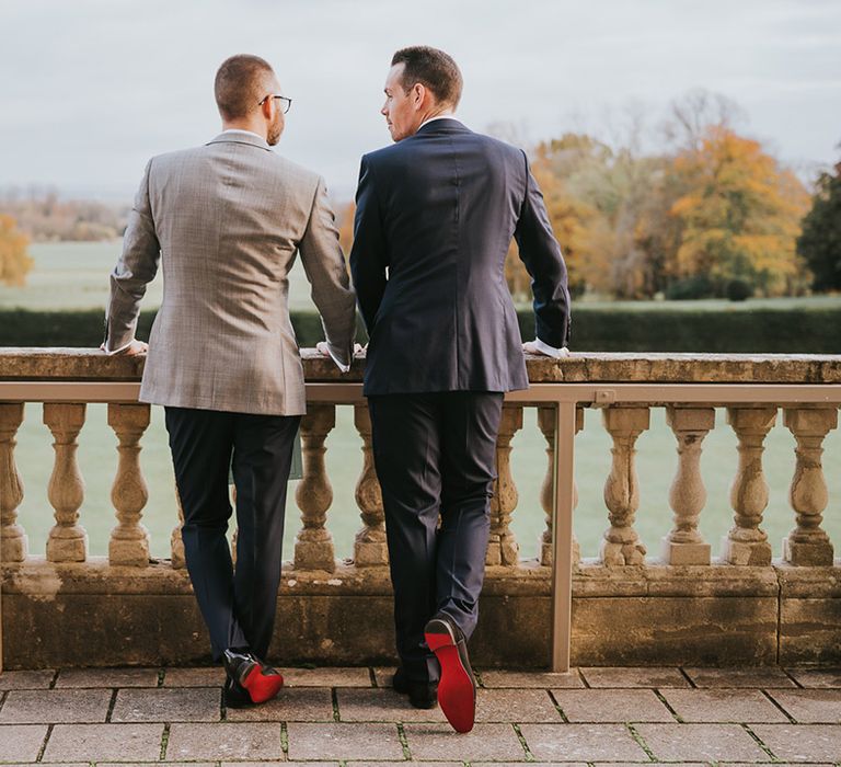 Groom stand together looking out at the view with their Louboutin groom shoes 