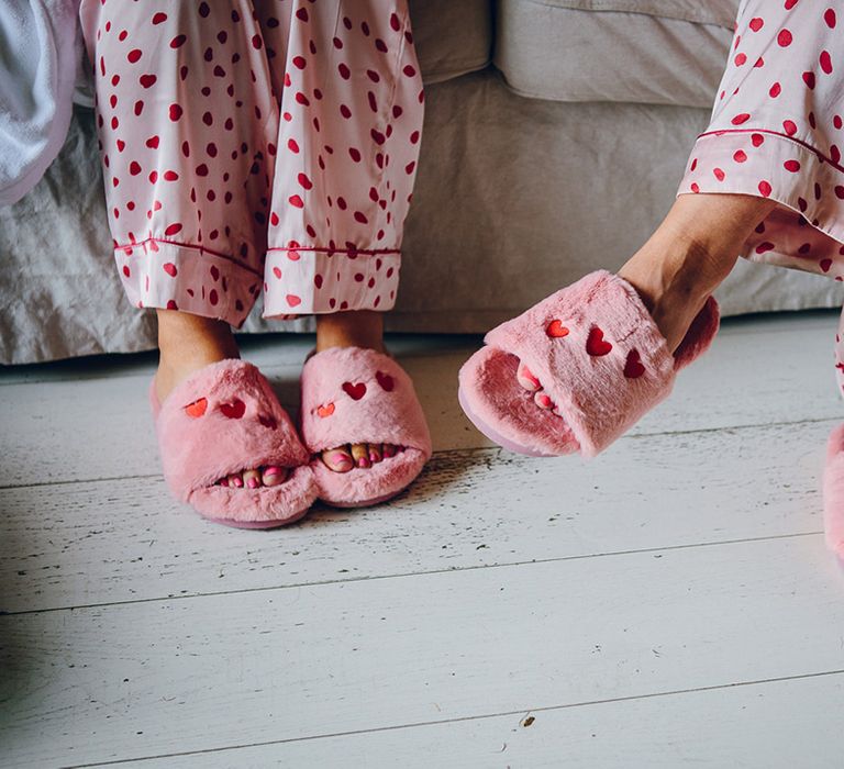 Bridesmaids in matching pink and red polka dot satin pyjamas and fluffy open toe slippers with embroidered red hearts