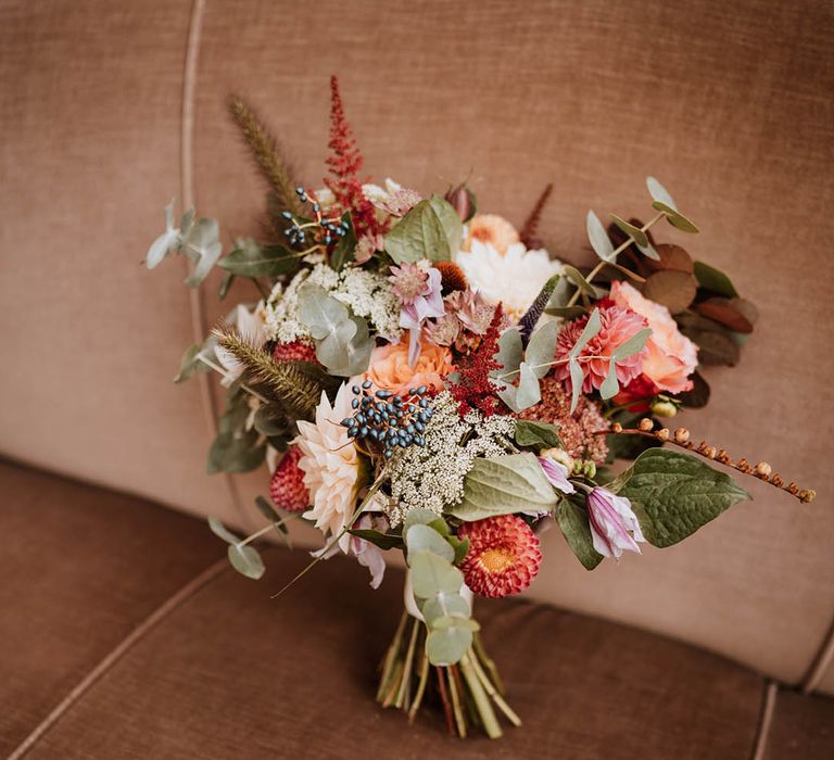 Wedding bouquet with white and pink carnations, garden roses, red strawflower, eucalyptus, baby’s-breath and various dried flowers 