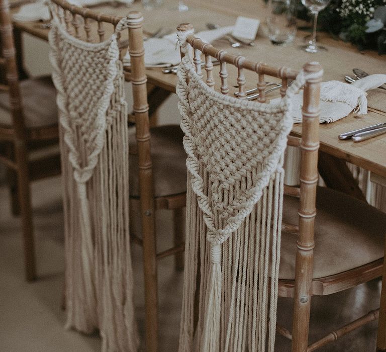 Wooden wedding chairs decorated with macrame wedding chair decor for a rustic wedding 