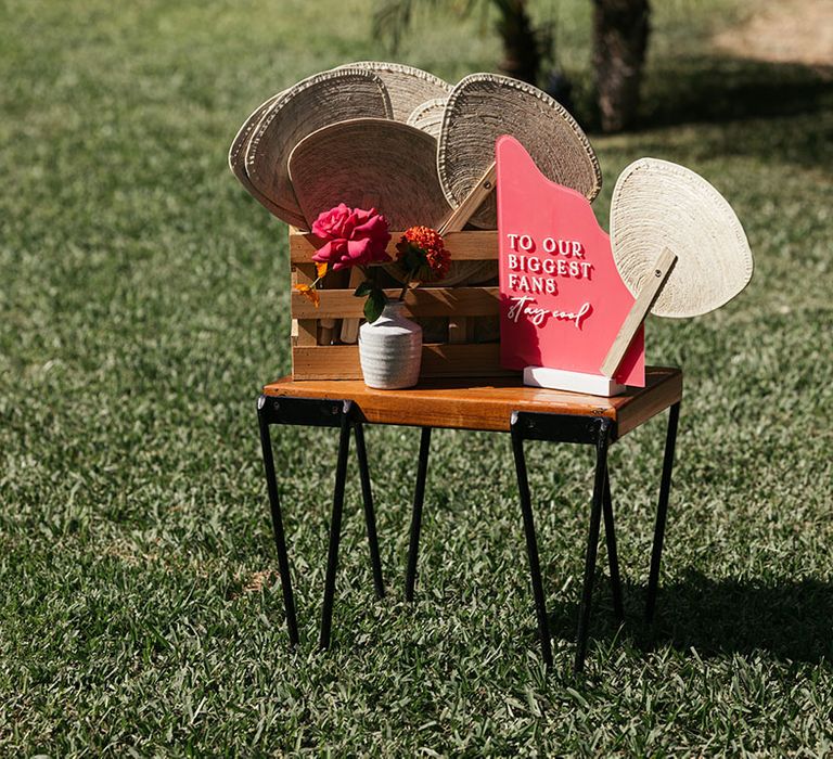 Colourful wedding signage beside fans for outdoor wedding ceremony in Mexico 