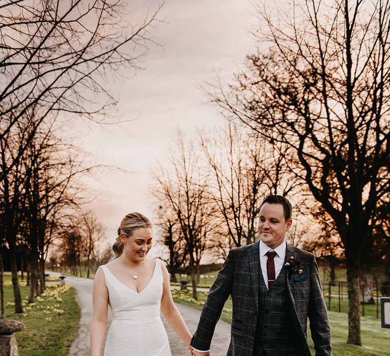 Bride in floral lace Karen Willis Holmes wedding dress with the groom in three piece Marc Darcy suit 